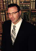A person wearing glasses and a suit

Description automatically generated with medium confidence